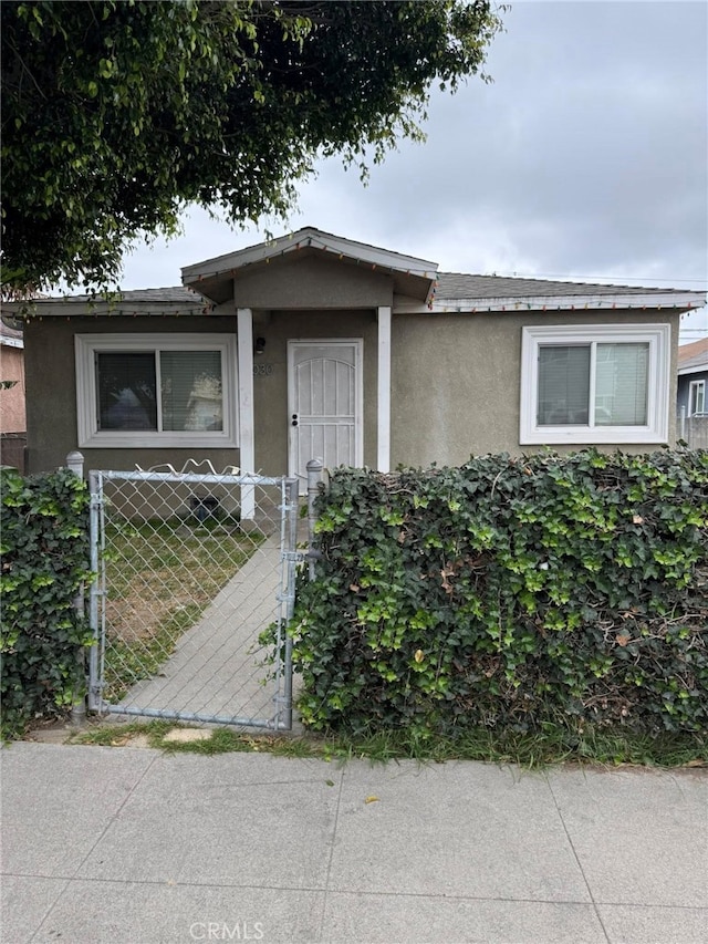 1030 E M St, Wilmington, CA 90744 - view of front of home featuring stucco siding and a gate
