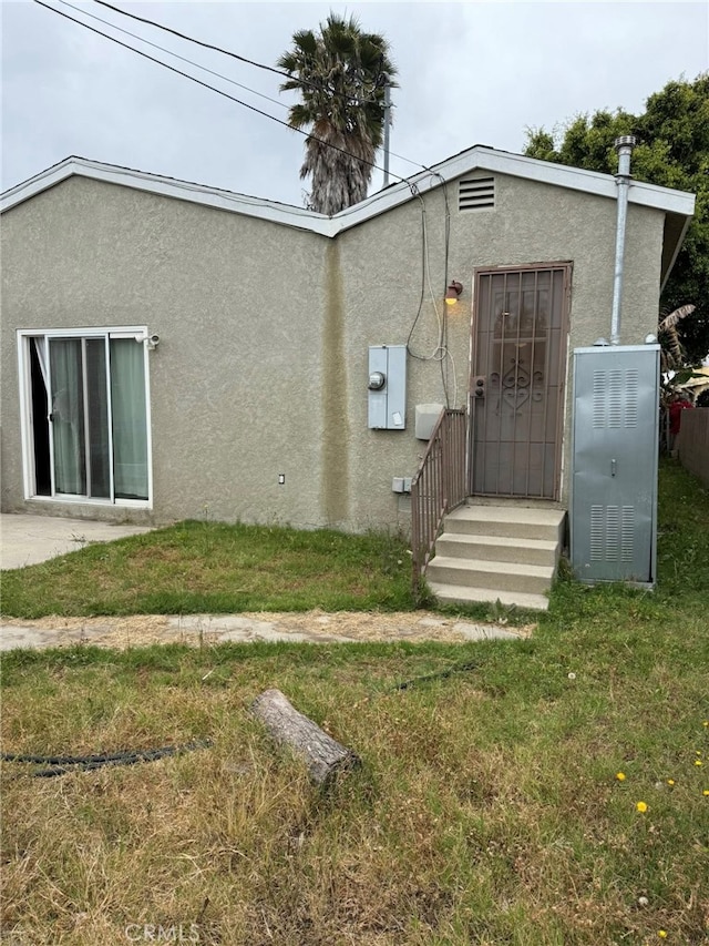 1030 E M St, Wilmington, CA 90744 - rear view of property featuring stucco siding and a yard