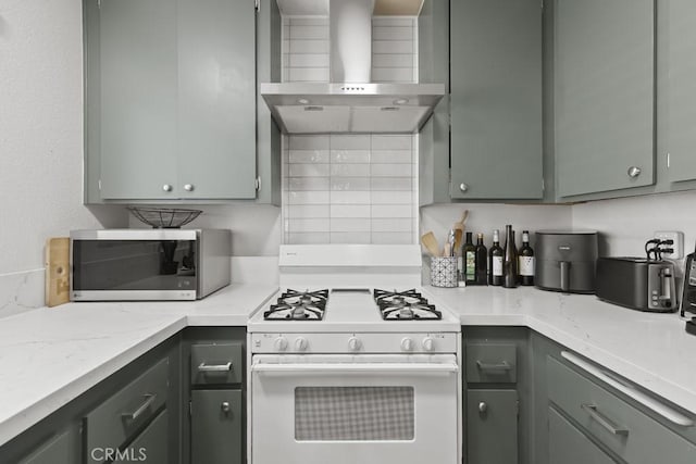16251 Malaga St, Fontana, CA 92336 - kitchen featuring white range with gas stovetop, wall chimney range hood, stainless steel microwave, tasteful backsplash, and gray cabinets