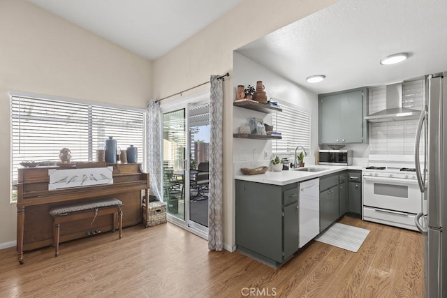 16251 Malaga St, Fontana, CA 92336 - kitchen with wall chimney range hood, appliances with stainless steel finishes, gray cabinets, a sink, and light wood-style floors