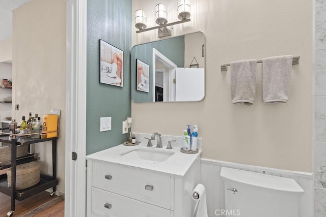 16251 Malaga St, Fontana, CA 92336 - bathroom with a wainscoted wall, vanity, wood finished floors, and toilet