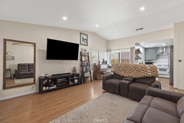 16251 Malaga St, Fontana, CA 92336 - living room featuring light wood finished floors, vaulted ceiling, baseboards, and recessed lighting