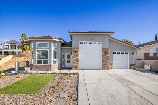 18189 Kalin Ranch Dr, Victorville, CA 92395 - view of front facade with stone siding, a garage, driveway, stucco siding, and a tiled roof