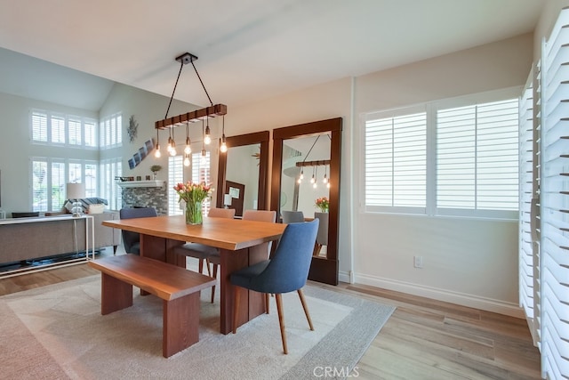 7411 Brava St, Carlsbad, CA 92009 - dining space with light wood-style flooring, a fireplace, and baseboards