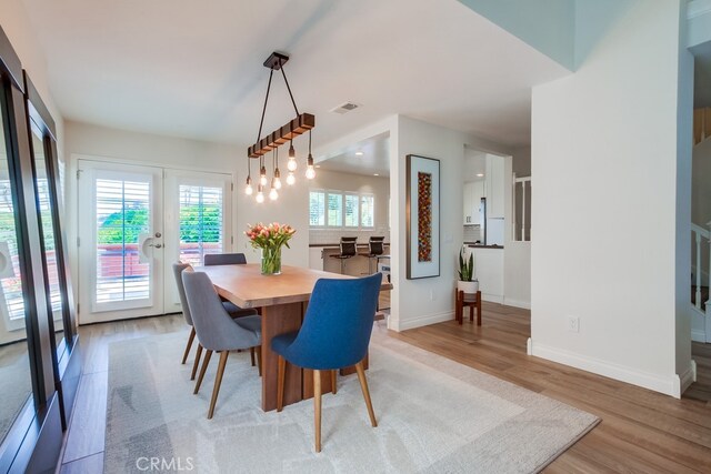 7411 Brava St, Carlsbad, CA 92009 - dining area with light wood-style flooring, baseboards, and stairway