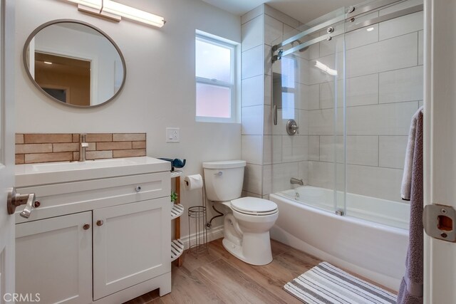7411 Brava St, Carlsbad, CA 92009 - full bath featuring wood finished floors, toilet, vanity, baseboards, and enclosed tub / shower combo