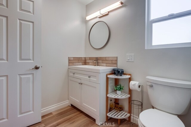 7411 Brava St, Carlsbad, CA 92009 - bathroom featuring toilet, baseboards, wood finished floors, and vanity