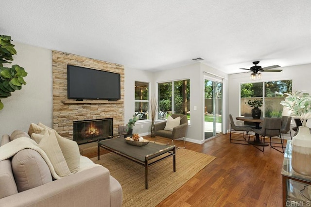 32175 Via Flore, Temecula, CA 92592 - living room with wood finished floors, ceiling fan, a stone fireplace, and a textured ceiling