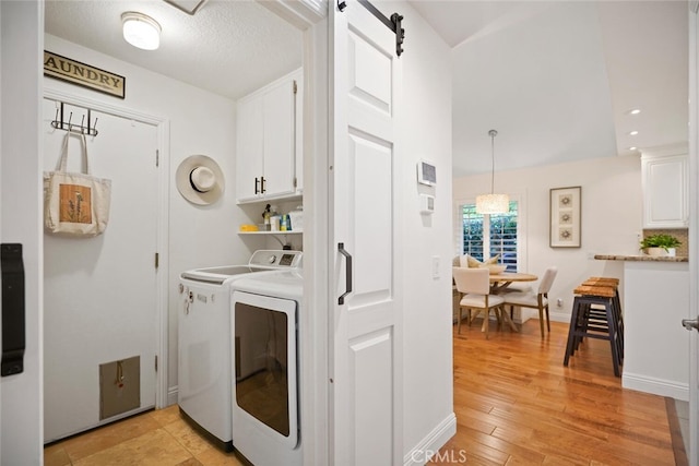 6617 Oak Forest Dr, Oak Park, CA 91377 - washroom featuring washer and clothes dryer, cabinet space, and light wood finished floors