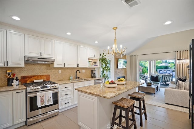 6617 Oak Forest Dr, Oak Park, CA 91377 - kitchen featuring appliances with stainless steel finishes, under cabinet range hood, vaulted ceiling, tasteful backsplash, and a sink