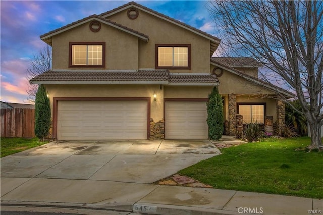 645 Bryce Ln, Beaumont, CA 92223 - view of front of house with an attached garage, stucco siding, driveway, a tile roof, and stone siding