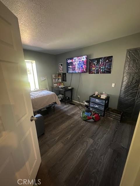 11420 Lasselle St, Moreno Valley, CA 92557 - bedroom with wood finished floors and a textured ceiling