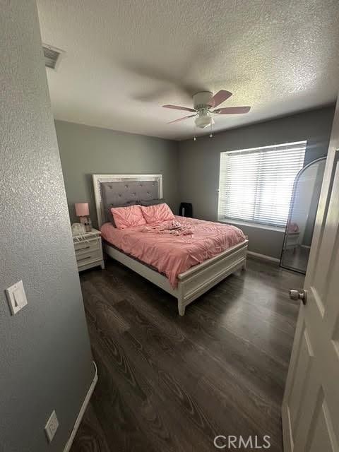 11420 Lasselle St, Moreno Valley, CA 92557 - bedroom with wood finished floors, a ceiling fan, a textured ceiling, and baseboards