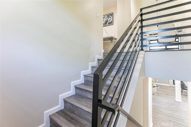 17465 Tuscan Dr, Granada Hills, CA 91344 - staircase featuring baseboards, wood finished floors, and a high ceiling