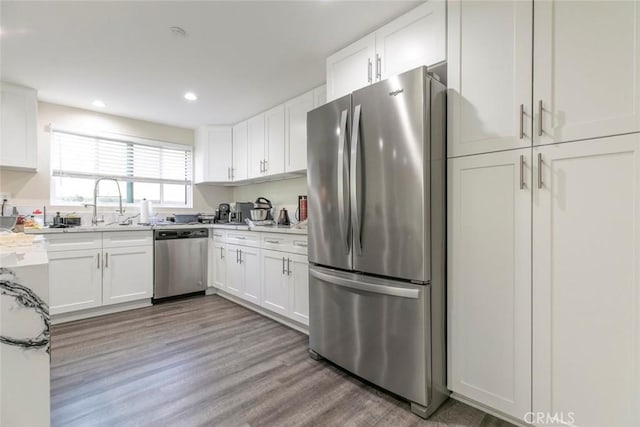17465 Tuscan Dr, Granada Hills, CA 91344 - kitchen featuring appliances with stainless steel finishes, white cabinetry, wood finished floors, light countertops, and recessed lighting