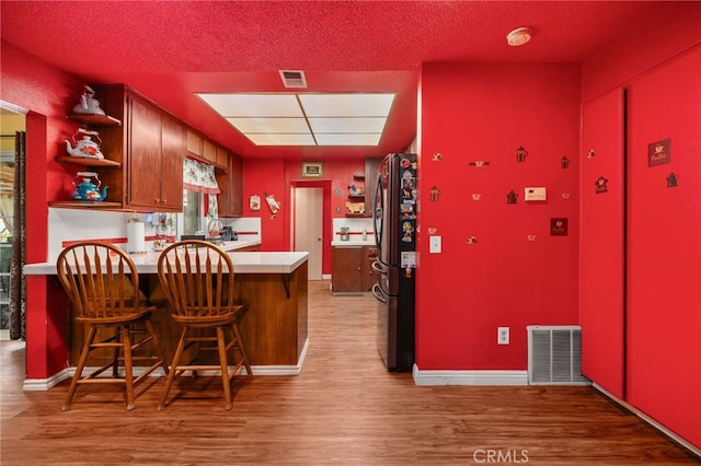 756 W Fontlee Ln, Rialto, CA 92376 - kitchen featuring open shelves, freestanding refrigerator, light wood-style flooring, a peninsula, and light countertops