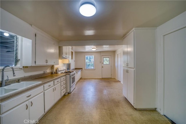 502 Robert Ct, Nipomo, CA 93444 - kitchen with gas range gas stove, a sink, white cabinetry, light floors, and exhaust hood