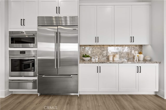 59 Longchamp, Irvine, CA 92602 - kitchen featuring built in fridge, a warming drawer, light wood-type flooring, light stone counters, and tasteful backsplash