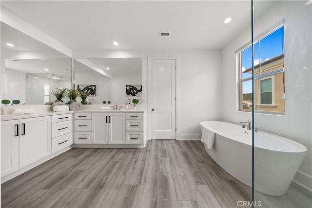 59 Longchamp, Irvine, CA 92602 - bathroom with double vanity, wood finished floors, a freestanding bath, recessed lighting, and baseboards