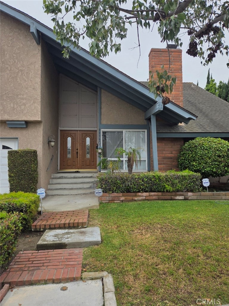 6036 Jeffrey Mark St, Cypress, CA 90630 - entrance to property featuring stucco siding, a lawn, and a chimney