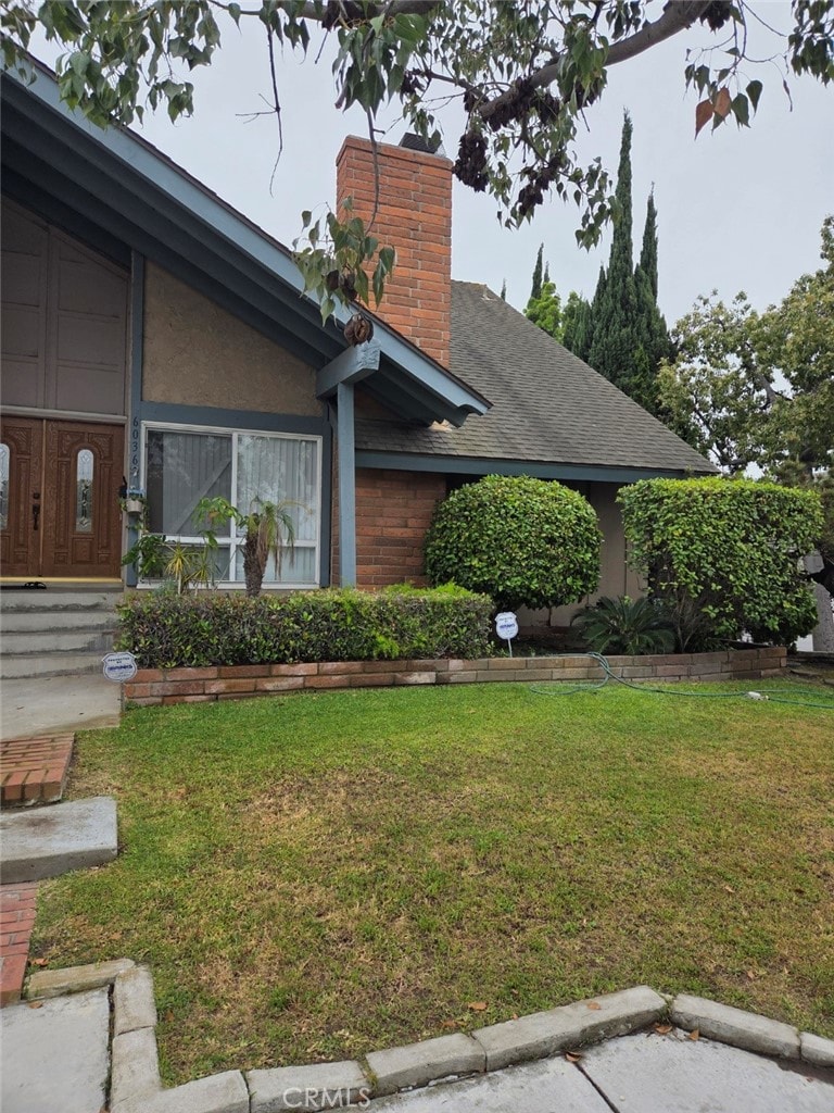 6036 Jeffrey Mark St, Cypress, CA 90630 - view of front of home with a front yard, a chimney, and roof with shingles