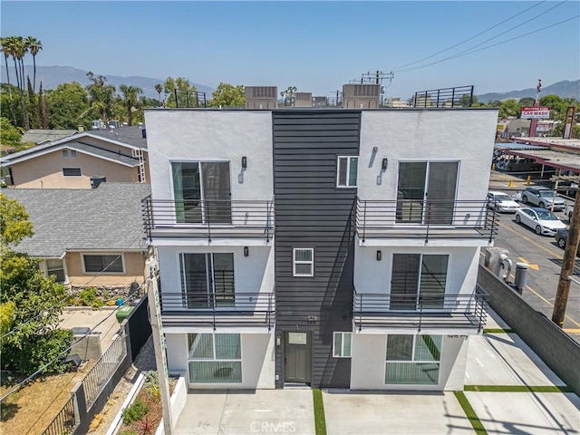 5218 Auckland Ave, Toluca Lake, CA 91601 - back of house with stucco siding, a balcony, and a mountain view