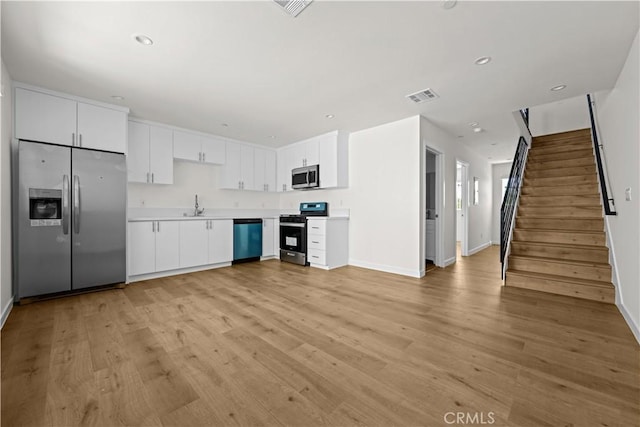 5218 Auckland Ave, Toluca Lake, CA 91601 - kitchen with stainless steel appliances, a sink, light countertops, baseboards, and light wood finished floors