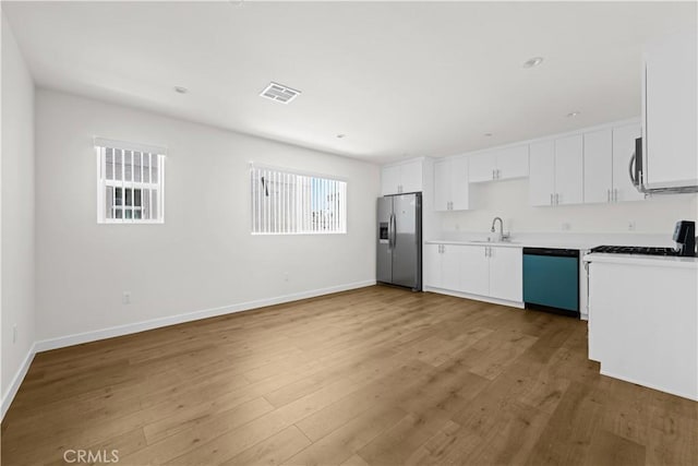 5218 Auckland Ave, Toluca Lake, CA 91601 - kitchen with stainless steel appliances, wood finished floors, light countertops, and white cabinets