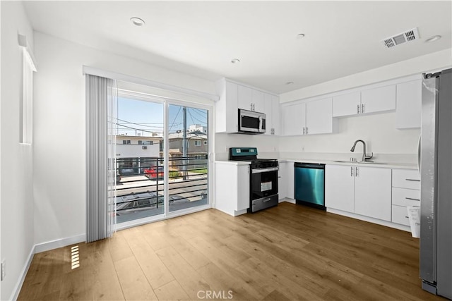 5218 Auckland Ave, Toluca Lake, CA 91601 - kitchen featuring stainless steel appliances, a sink, wood finished floors, and white cabinets