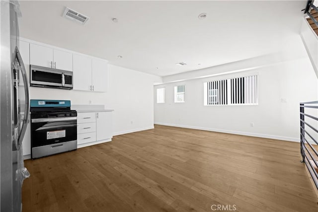 5218 Auckland Ave, Toluca Lake, CA 91601 - kitchen with stainless steel appliances, wood finished floors, white cabinetry, baseboards, and light countertops