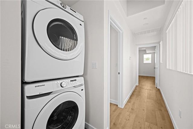 5218 Auckland Ave, Toluca Lake, CA 91601 - washroom with stacked washing machine and dryer, light wood finished floors, and baseboards