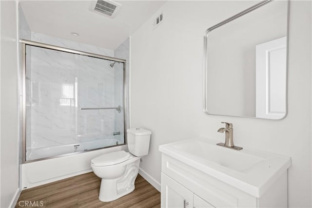 5218 Auckland Ave, Toluca Lake, CA 91601 - bathroom featuring toilet, wood finished floors, combined bath / shower with glass door, vanity, and baseboards
