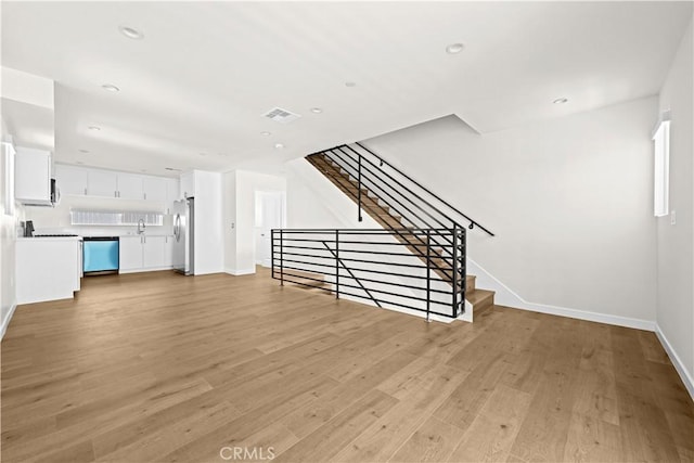 5218 Auckland Ave, Toluca Lake, CA 91601 - unfurnished living room featuring light wood-type flooring, baseboards, recessed lighting, a sink, and stairs