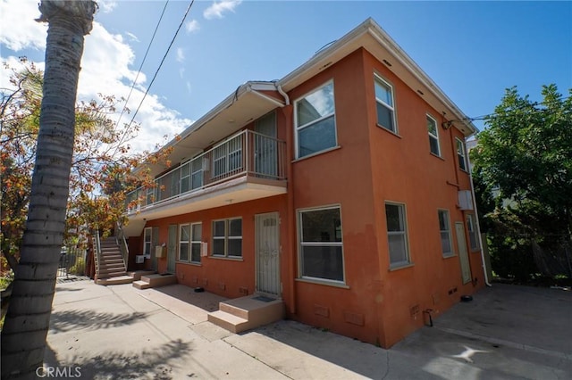 1631 E 4th St, Long Beach, CA 90802 - rear view of house with crawl space, stucco siding, and stairway