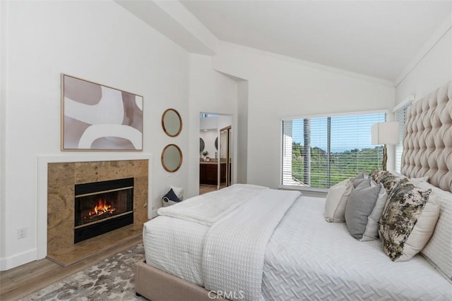 24882 Summerwind, Dana Point, CA 92629 - bedroom featuring vaulted ceiling, wood finished floors, crown molding, and a tile fireplace