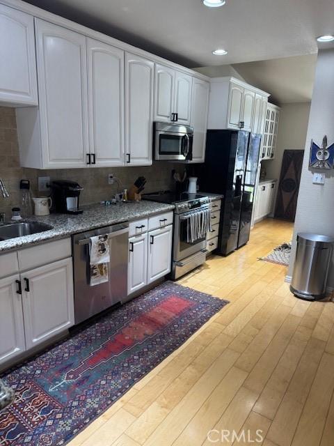 2400 Altisma Way Unit B, Carlsbad, CA 92009 - kitchen featuring appliances with stainless steel finishes, white cabinets, a sink, recessed lighting, and backsplash