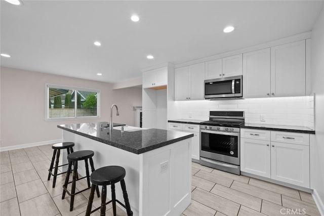 17148 Stare St, Northridge, CA 91325 - kitchen featuring stainless steel appliances, a sink, decorative backsplash, white cabinets, and a breakfast bar