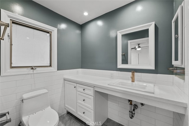 17148 Stare St, Northridge, CA 91325 - bathroom featuring toilet, ceiling fan, vanity, tile walls, and wainscoting