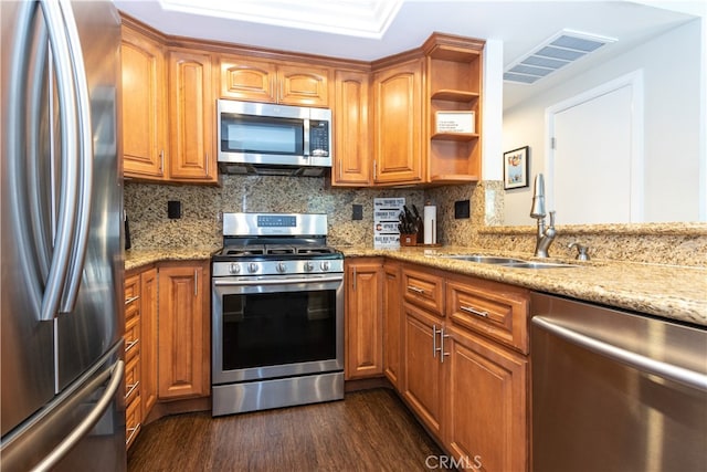 28956 Canyon Lake Dr Unit 43, Lake Forest, CA 92679 - kitchen featuring stainless steel appliances, light stone countertops, dark wood-style floors, brown cabinets, and open shelves