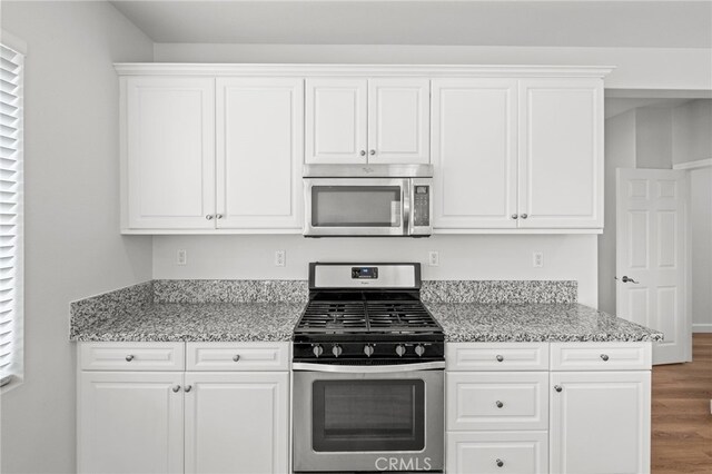 30183 Redding Ave, Murrieta, CA 92563 - kitchen with stainless steel appliances, wood finished floors, white cabinets, and light stone countertops
