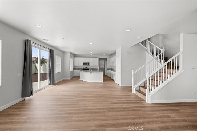 30183 Redding Ave, Murrieta, CA 92563 - unfurnished living room featuring stairway, baseboards, recessed lighting, and light wood-type flooring
