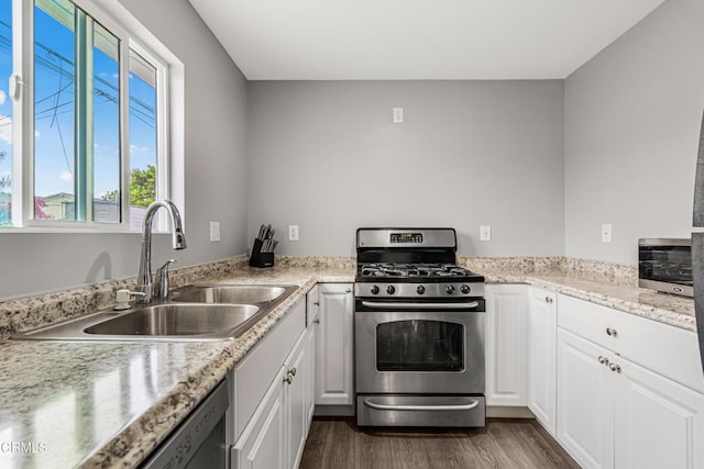 124 N Driskill St, Oxnard, CA 93030 - kitchen with stainless steel appliances, a sink, dark wood-type flooring, and white cabinetry