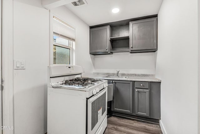 124 N Driskill St, Oxnard, CA 93030 - kitchen featuring white gas range oven, gray cabinetry, a sink, dark wood finished floors, and recessed lighting