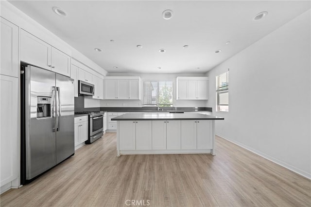 143 Frame, Irvine, CA 92618 - kitchen with stainless steel appliances, light wood-style flooring, a center island, white cabinetry, and recessed lighting