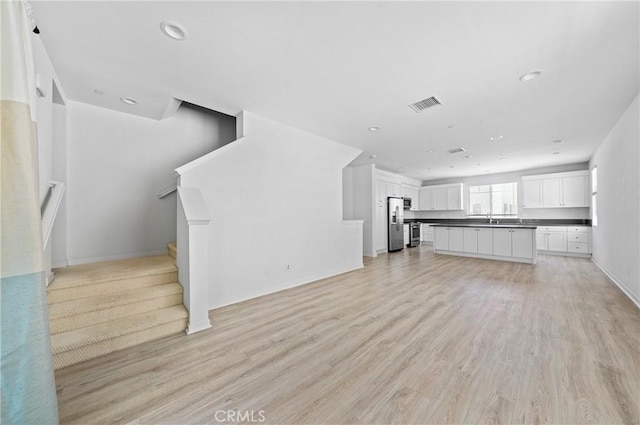 143 Frame, Irvine, CA 92618 - unfurnished living room with light wood-style floors, recessed lighting, stairway, and baseboards