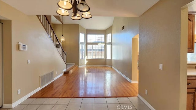 7240 Meadowlark Pl, Rancho Cucamonga, CA 91701 - entryway featuring stairs, a chandelier, light wood finished floors, baseboards, and a towering ceiling