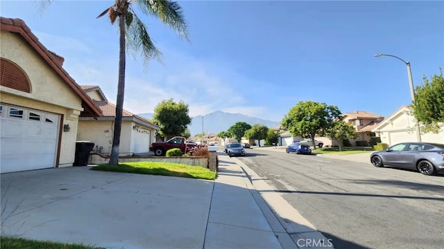 7240 Meadowlark Pl, Rancho Cucamonga, CA 91701 - view of asphalt street featuring a mountain view, a residential view, street lights, and sidewalks