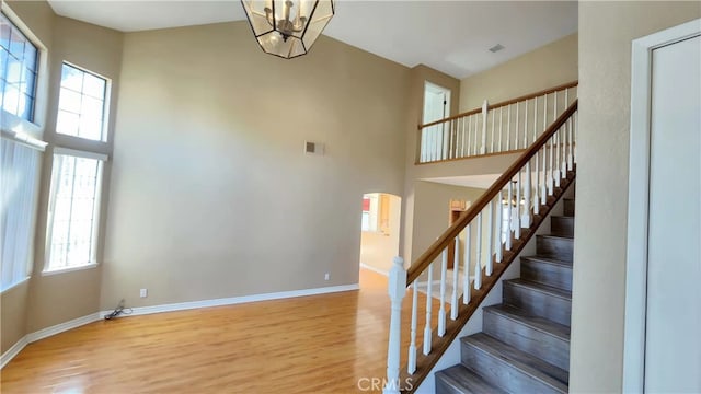 7240 Meadowlark Pl, Rancho Cucamonga, CA 91701 - stairway with wood finished floors, a towering ceiling, plenty of natural light, and baseboards