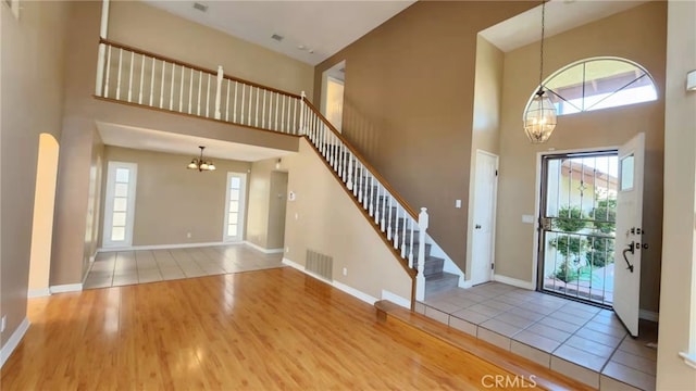 7240 Meadowlark Pl, Rancho Cucamonga, CA 91701 - foyer entrance featuring a chandelier, a towering ceiling, wood finished floors, healthy amount of natural light, and stairway