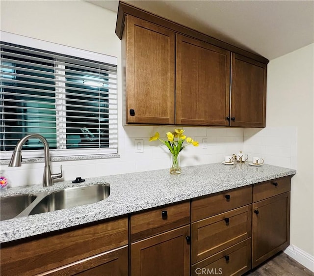 1385 N San Pablo Ave, Fresno, CA 93728 - kitchen with a sink, light stone countertops, decorative backsplash, dark wood finished floors, and baseboards